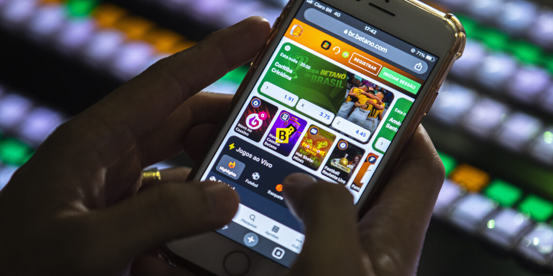 Uma pessoa manipula um celular em um site de apostas esportivas